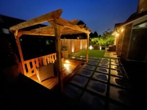 Sfeervolle LED tuinverlichting gemonteerd onder een houten pergola.