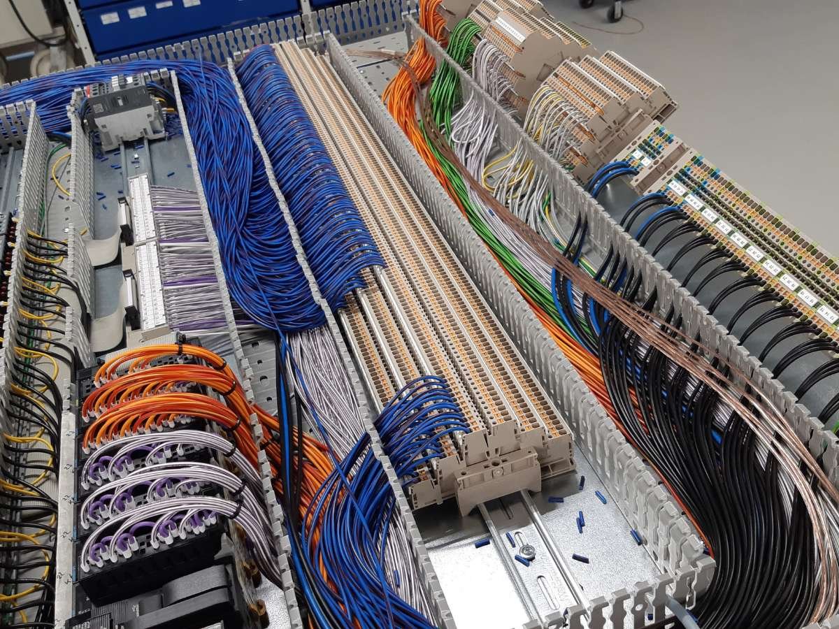 Georganiseerd kabelmanagement met gestructureerde bekabeling in een industriële besturingskast.