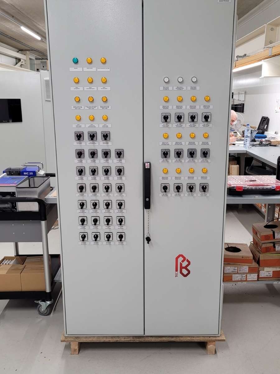Grote industriële besturingskast met een overzicht van professionele schakelaars en signaallampen.