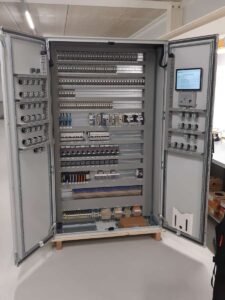 Grote industriële besturingskast opengeklapt met ingebouwd digitaal touchscreen.