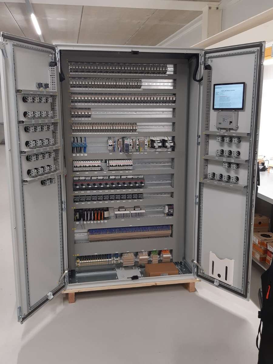 Grote industriële besturingskast opengeklapt met ingebouwd digitaal touchscreen.
