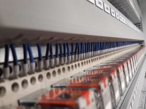 Detailweergave van professionele componenten en blauwe bedrading in een schakelkast.