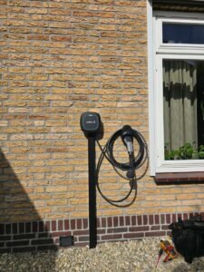 Laadpaal montage aan een bakstenen muur voor een elektrische auto in Den Haag.